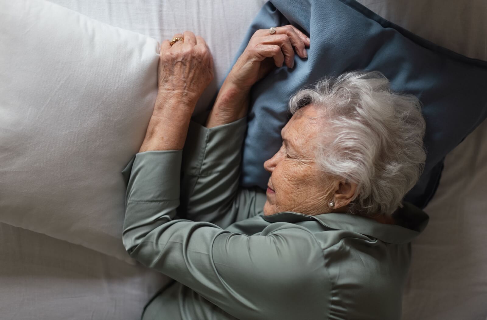 Older adult woman with dementia sleeping soundly in bed.