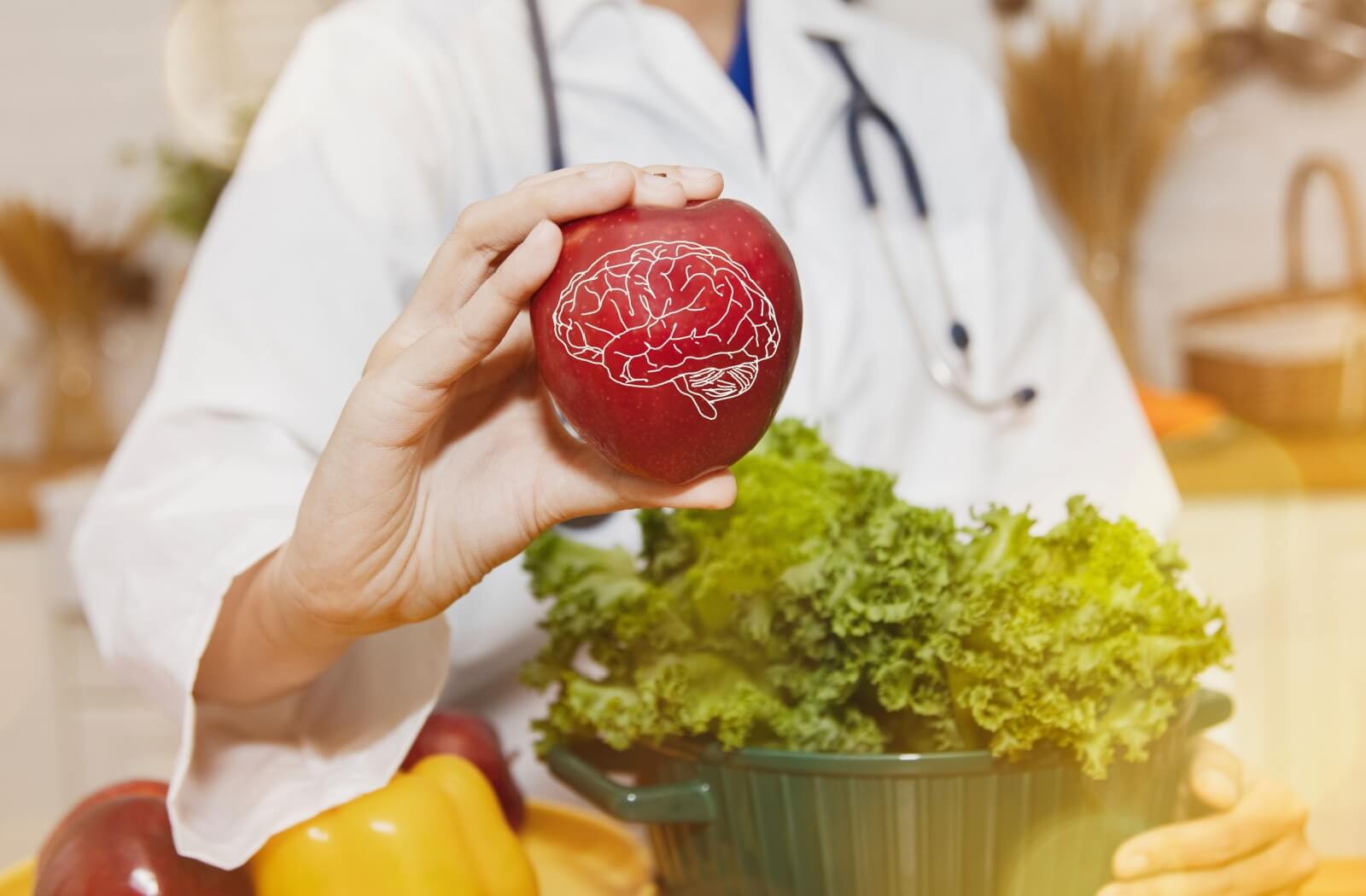 A doctor in a kitchen surrounded by vegetables holds out an apple with a brain on it, signalling food to support brain health